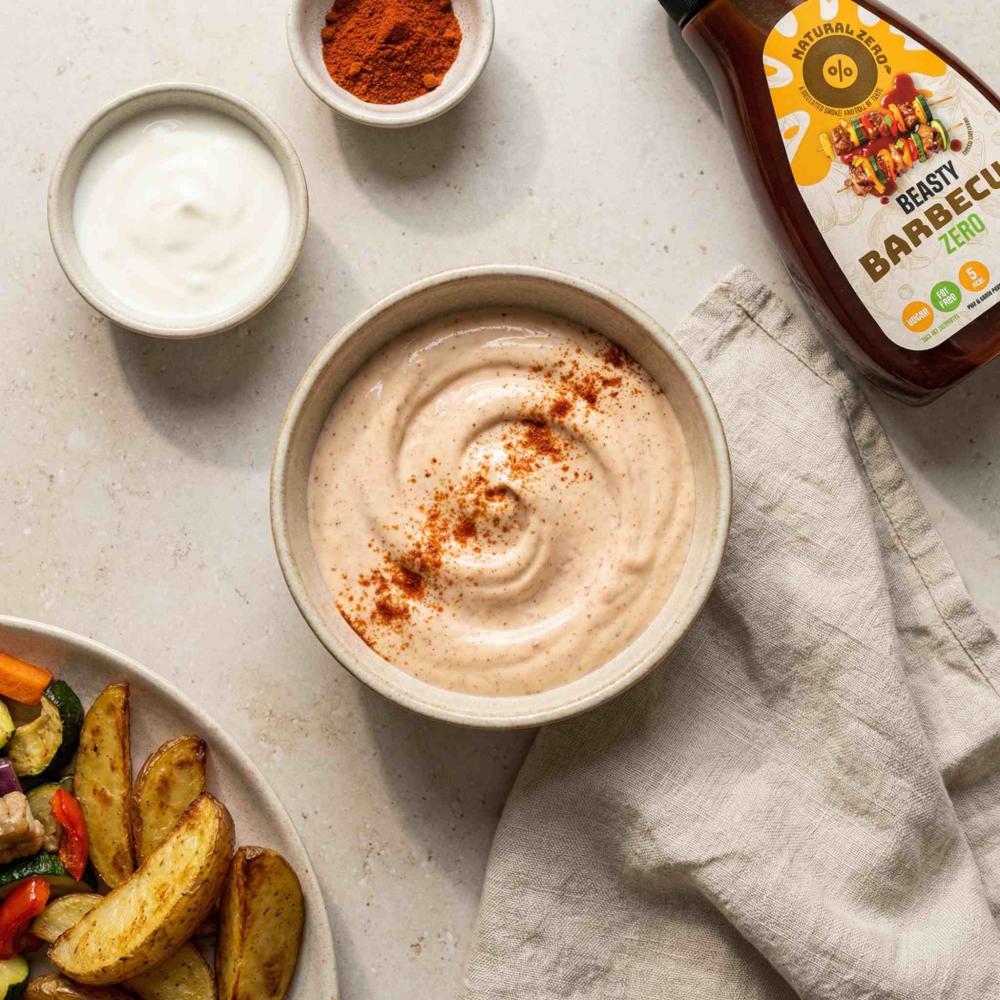 A small ceramic bowl filled with a light BBQ dip made with Beasty BBQ Zero and yoghurt, gently swirled. Topped with a pinch of smoked paprika powder.
