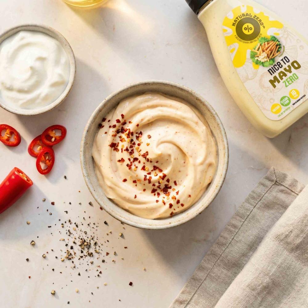 A small ceramic bowl filled with a creamy spicy mayo dip made with Nice to Mayo Zero, softly swirled and topped with a pinch of chili flakes.