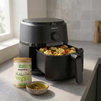 een open airfryer met geroosterde groenten en een potje habibie veggie er naast