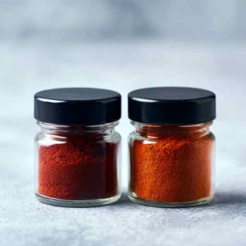 2 potjes paprika poeder. Een met gerookt paprika poeder en 1 normale gemalen paprika poeder